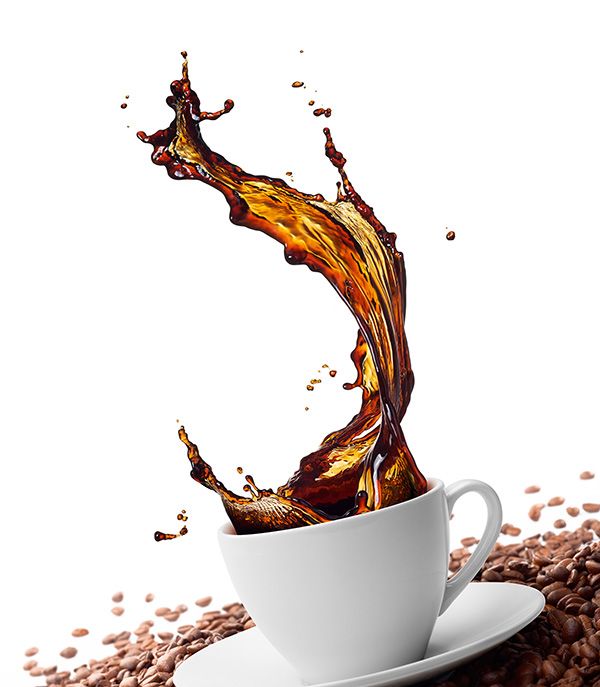 taza de café con salpicaduras rodeada de granos de café